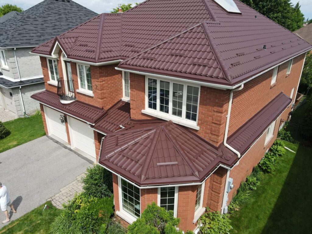 Drone view of a close-up aerial shot of dark red metal tile roof
